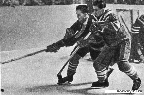 Советский хоккеист Генрих Сидоренков стремится движением туловища оттеснить шведского игрока и завладеть шайбой